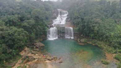 Adventure Tours - Stunning aerial view of a waterfall surrounded by dense jungle in Meghalaya, India.