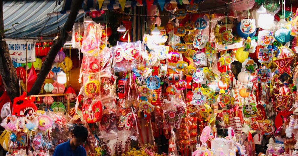 Local Artisans Markets - Colorful lanterns at a bustling night market stall with a customer on a scooter nearby.