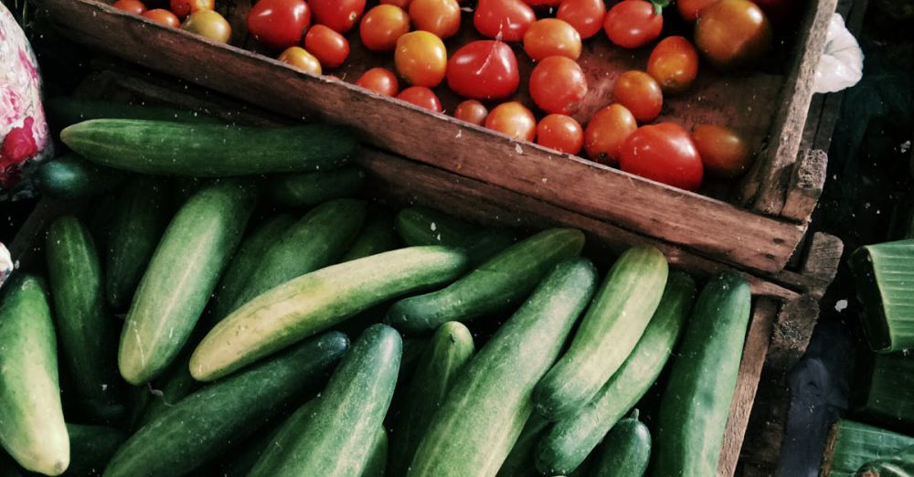 BC Farmers Markets - Vibrant tomatoes and cucumbers on display at a local farmers market.