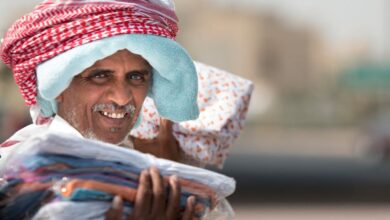 Pet-Friendly Markets - Friendly street vendor in Al Jahra, Kuwait, showcasing traditional wear.