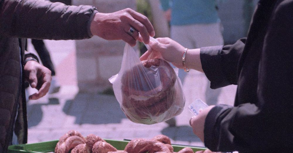 Bread Markets - A street vendor sells fresh pretzels outdoors in Istanbul, capturing a cultural exchange.