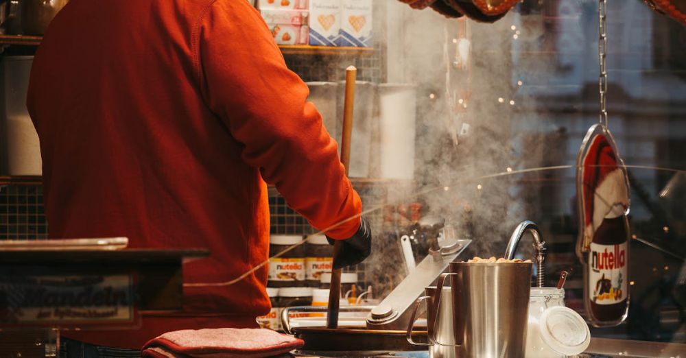 Sweet Treats Markets - A vendor in a red coat serves treats at a festive German market stall adorned with heart-shaped gingerbreads.