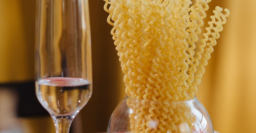 Wine Markets - Glass of wine and pasta on a checkered tablecloth, with lemons and vibrant colors.