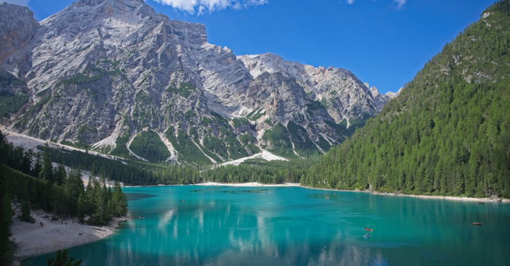 Popular Canoe Trails - Panoramic view of Braies Lake with turquoise water and majestic mountains in South Tyrol, Italy.