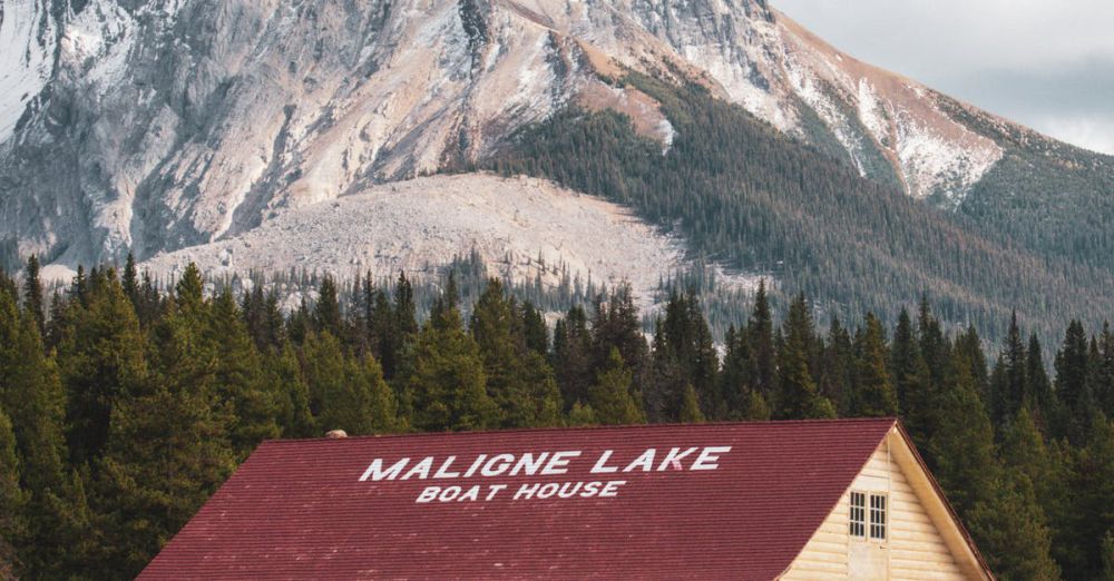 Rockies Canoe Portaging - Picturesque Maligne Lake boathouse against a stunning mountain backdrop in Jasper National Park, Alberta.