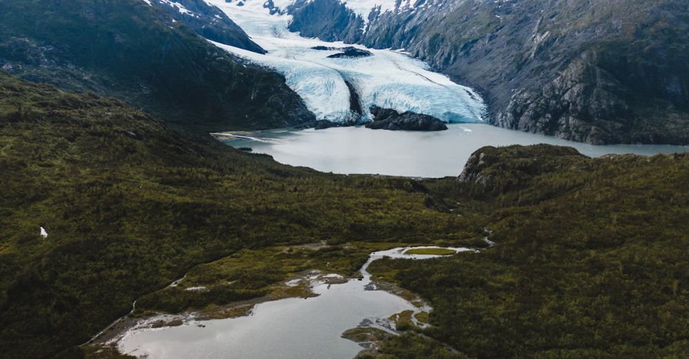 Adventure Portaging - A stunning aerial view of a glacier in Alaska with surrounding mountain ranges.