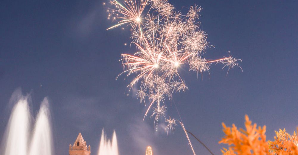 Outdoor Winter Festivals - Vibrant fireworks light up the night sky above a festive town square celebrating the holiday season.