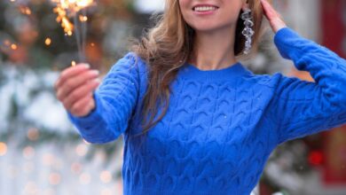 Fireworks Winter Festivals - Smiling woman enjoying a sparkler at an outdoor winter market, surrounded by holiday decorations.