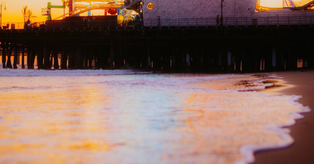 Popular Scenic Train Rides - Ferris wheel at Santa Monica Pier reflecting on the water during a stunning sunset.