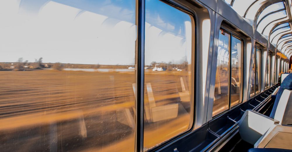 Luxury Scenic Train Rides - Interior of a modern train traveling at high speed with a scenic landscape view through large windows