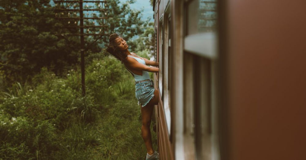 Scenic Train Ride Choice - Woman enjoying a thrilling train ride, leaning out a window amidst lush greenery.