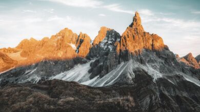 Beginner Rock Climbing - Sunlit peaks of a majestic mountain range during sunrise with scenic view.