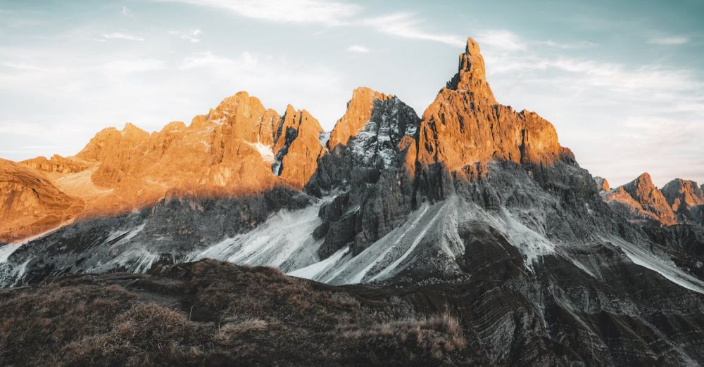 Beginner Rock Climbing - Sunlit peaks of a majestic mountain range during sunrise with scenic view.