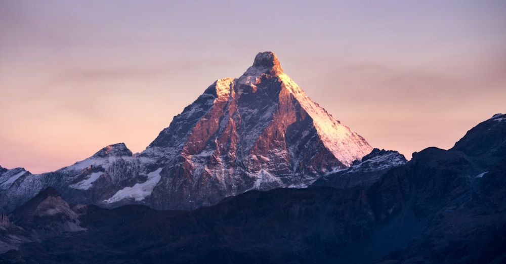 Scenic Rock Climbing - Stunning view of the Matterhorn mountain illuminated by the first light of sunrise against a colorful sky.