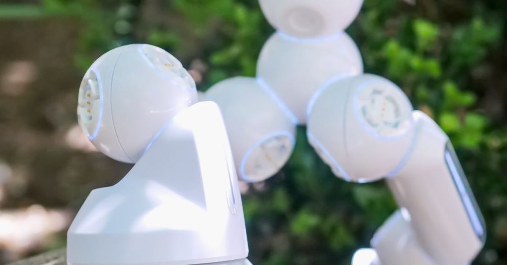 Advanced Rock Climbing - Close-up of a futuristic white robotic arm stepping over a rock outdoors.