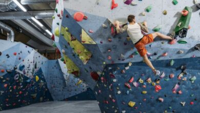 Sport Climbing - Man bouldering on colorful indoor climbing wall, showcasing athletic skills.