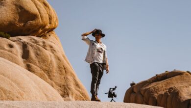 Solo Rock Climbing - A man stands atop desert rock formations, capturing the essence of adventure in a natural landscape.