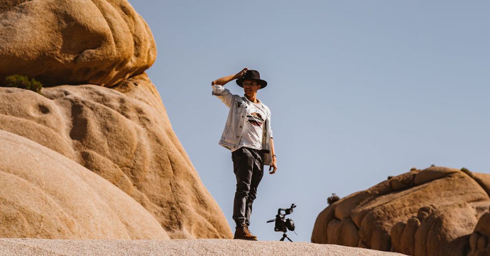 Solo Rock Climbing - A man stands atop desert rock formations, capturing the essence of adventure in a natural landscape.