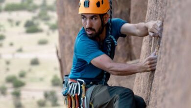 Rock Climbing Route Choice - A focused climber with safety gear ascends a rock face outdoors.