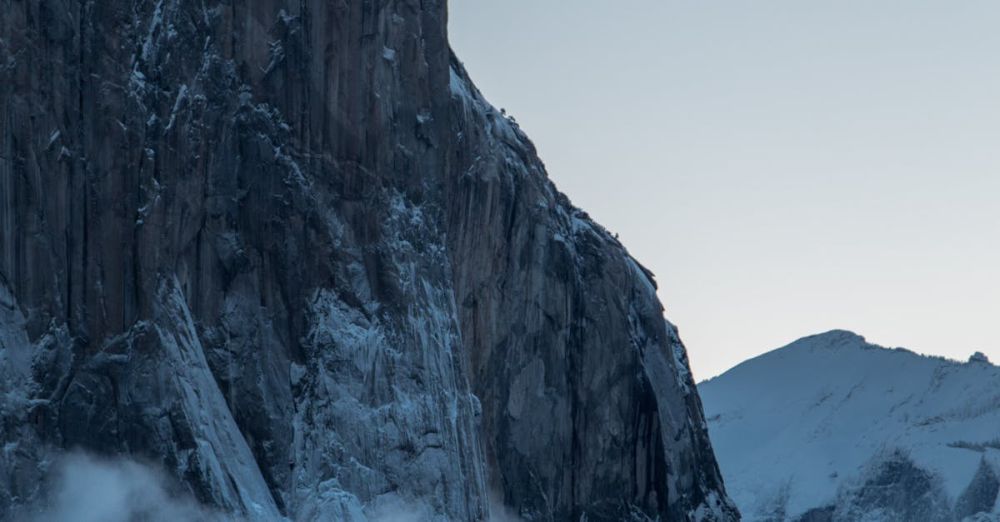 Winter Rock Climbing - Breathtaking winter scene featuring El Capitan in Yosemite, enveloped in snow and mist for a dramatic natural landscape.