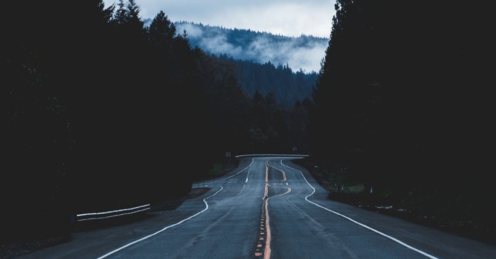 Long Route Climbing - A tranquil empty road leading through Oregon's misty forests under a cloudy sky.