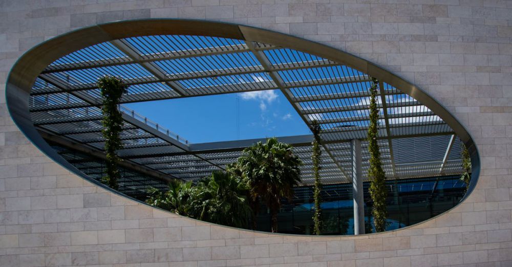 Urban Gardens - Futuristic building with lush greenery and a unique oval opening in Lisbon.