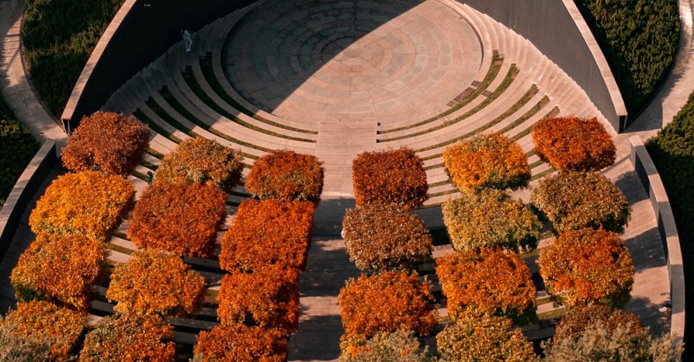 Sustainable Urban Gardens - Aerial view of contemporary amphitheater with colorful autumn trees, showcasing modern architecture.