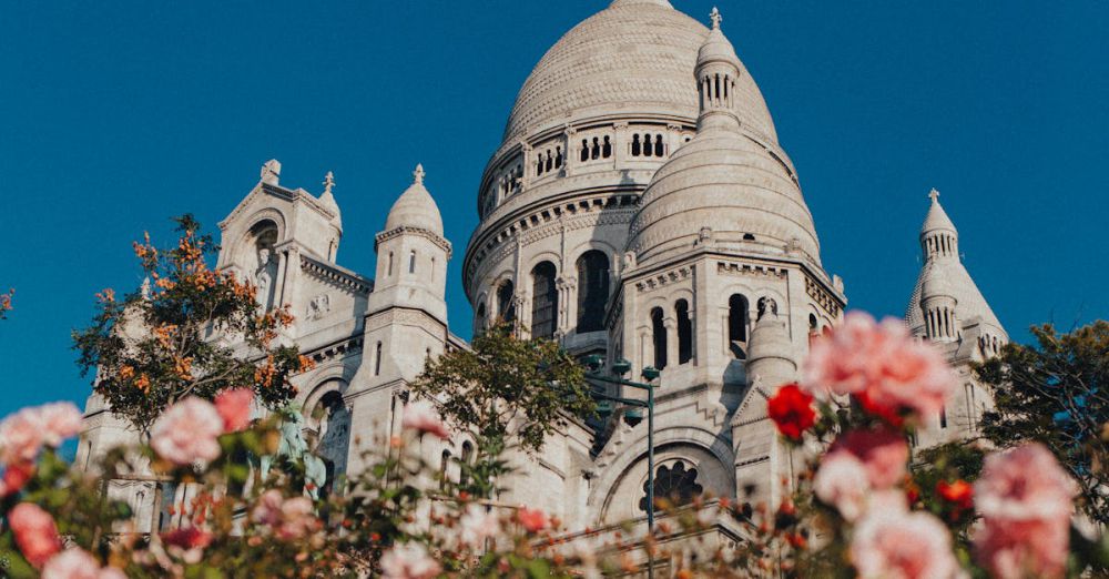 Beautiful Urban Gardens - Stunning view of Sacré-Cœur Basilica framed by colorful flowers in Paris, under a clear blue sky.