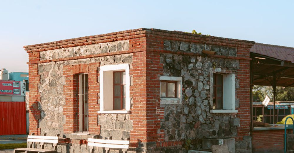 Small Space Urban Gardens - A quaint brick and stone building with benches in Atlixco, Puebla, Mexico.