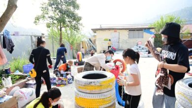 Workshop Urban Gardens - Children and adults collaborate on a colorful tire painting project in an outdoor community space.