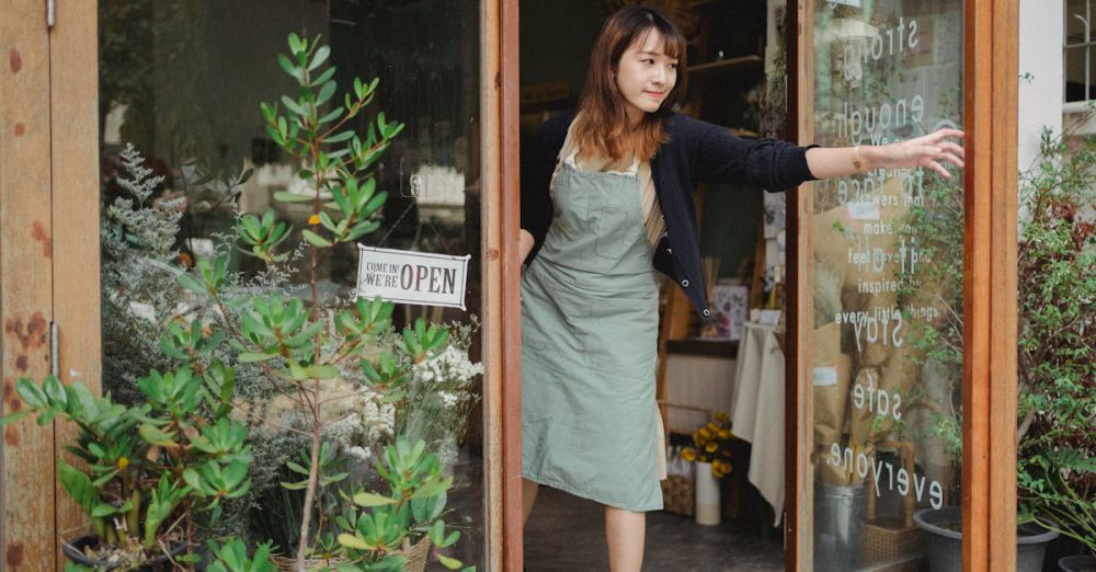 Community Gardening Urban Gardens - Tranquil florist in apron opening glass door of flower shop in daytime in city