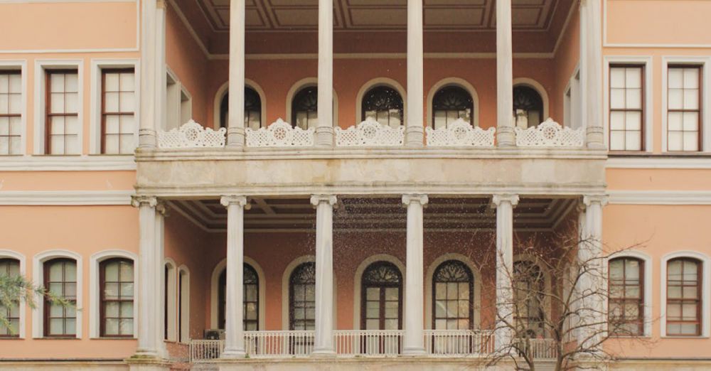 Public Space Urban Gardens - Neo-classical building facade in Istanbul, featuring columns and a reflecting pond in a tranquil setting.