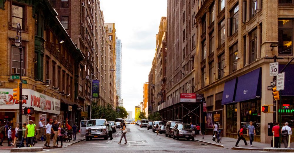 Streets - Lively urban street in New York City with pedestrians and vehicles on a sunny day.