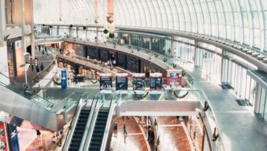 Malls - Spacious indoor shopping mall with glass ceilings and a modern design, including escalators and shops.