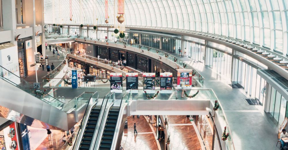 Malls - Spacious indoor shopping mall with glass ceilings and a modern design, including escalators and shops.