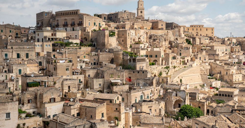 Districts - Scenic view of Matera's ancient stone dwellings under a blue sky.