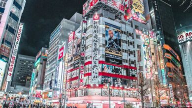 Districts - Explore the vibrant cityscape of Shinjuku, Tokyo at night with bright neon lights and bustling streets.