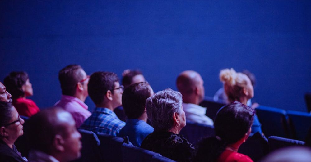 Events - An attentive group of adults seated at an indoor conference, focusing on a presentation.