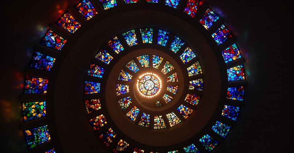 Art - Captivating spiral stained glass art with vibrant colors forming a dramatic eye-catching pattern.