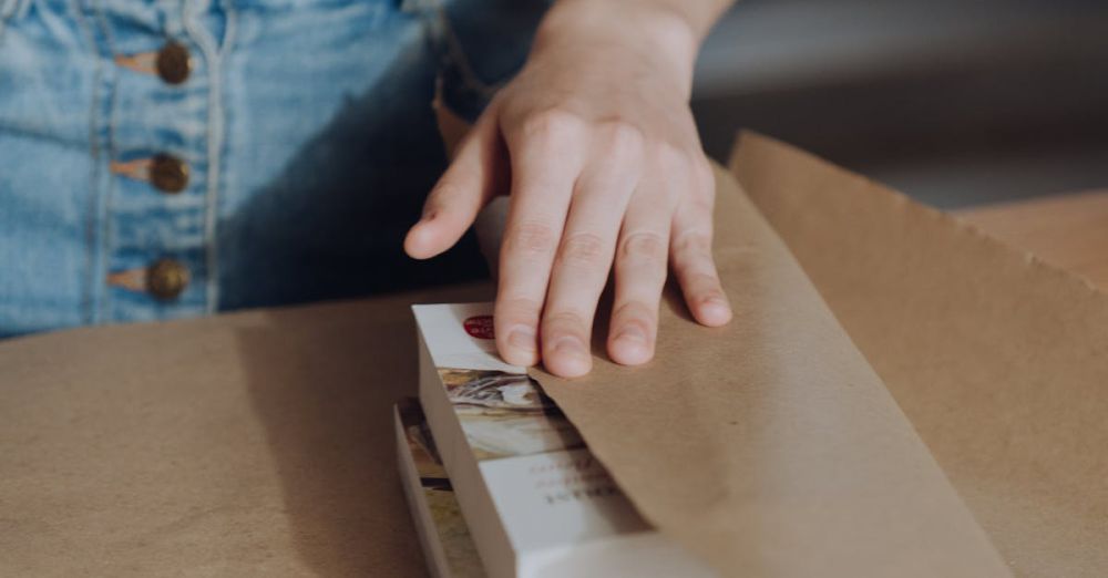 Educational Gifts - Person wrapping a book in craft paper, depicting a bookshop setting or gift wrapping service.