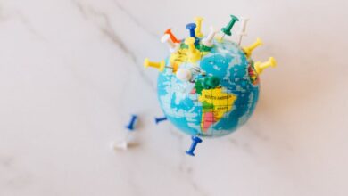 Locations - A globe decorated with colorful push pins on a marble surface represents global connections