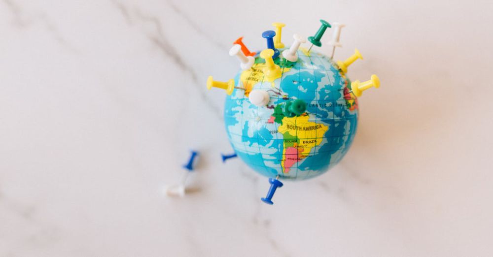 Locations - A globe decorated with colorful push pins on a marble surface represents global connections