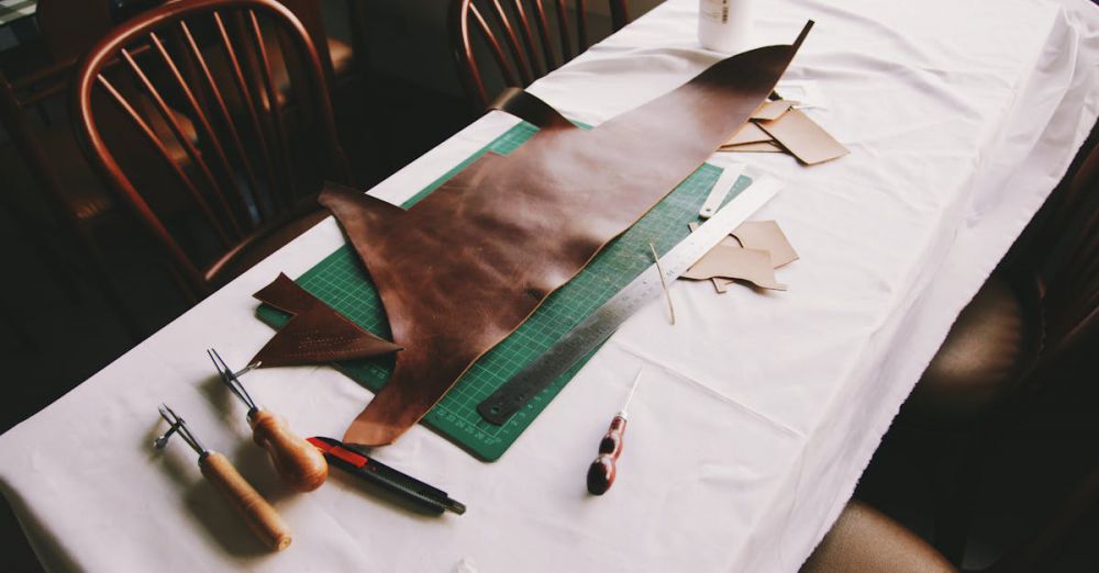 Leather - Intricate leather crafting setup with tools on a workshop table in Jakarta.