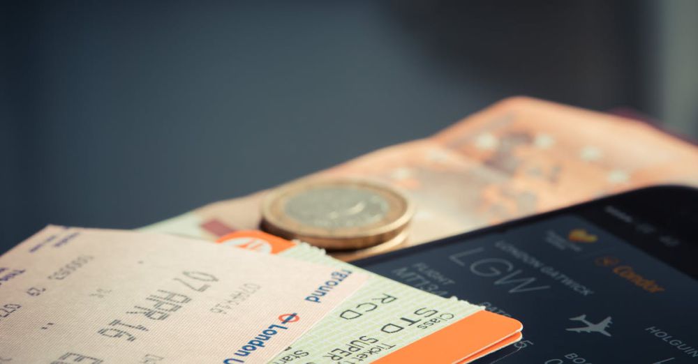 Tickets - Airline ticket with euro coins and smartphone displaying flight details.