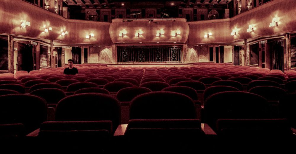 Theater - An elegant vintage theater with plush velvet seats and warm lighting, perfect for a serene cinematic experience.