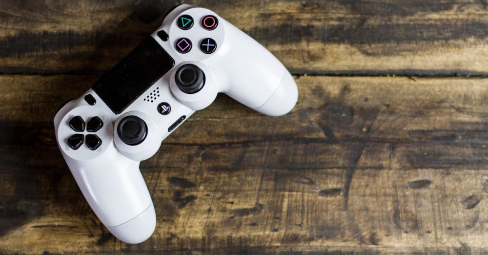 Games - White game controller resting on a rustic wooden surface, top view.