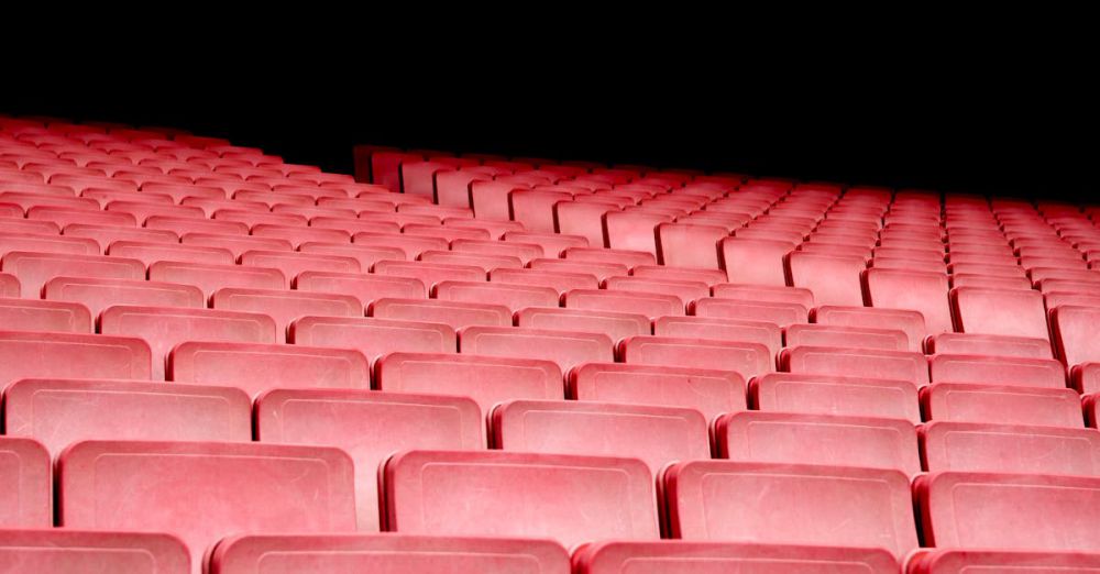 Musicals - Rows of red seats in an empty auditorium with dramatic lighting.