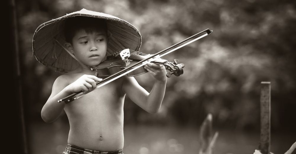 Talent - A young boy with a traditional hat plays the violin outdoors, showcasing musical talent and passion.