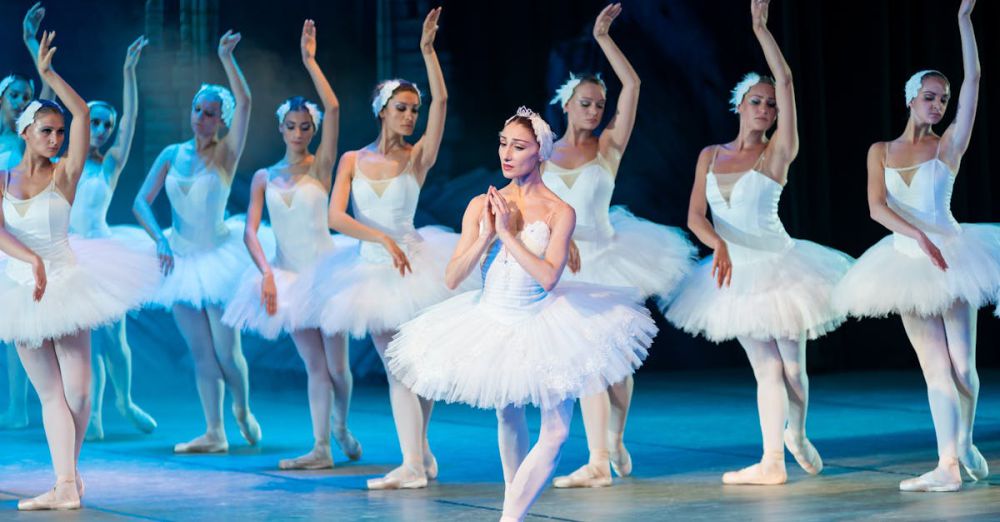 Ballet - Elegant ballerinas performing Swan Lake ballet on stage in classic tutus.