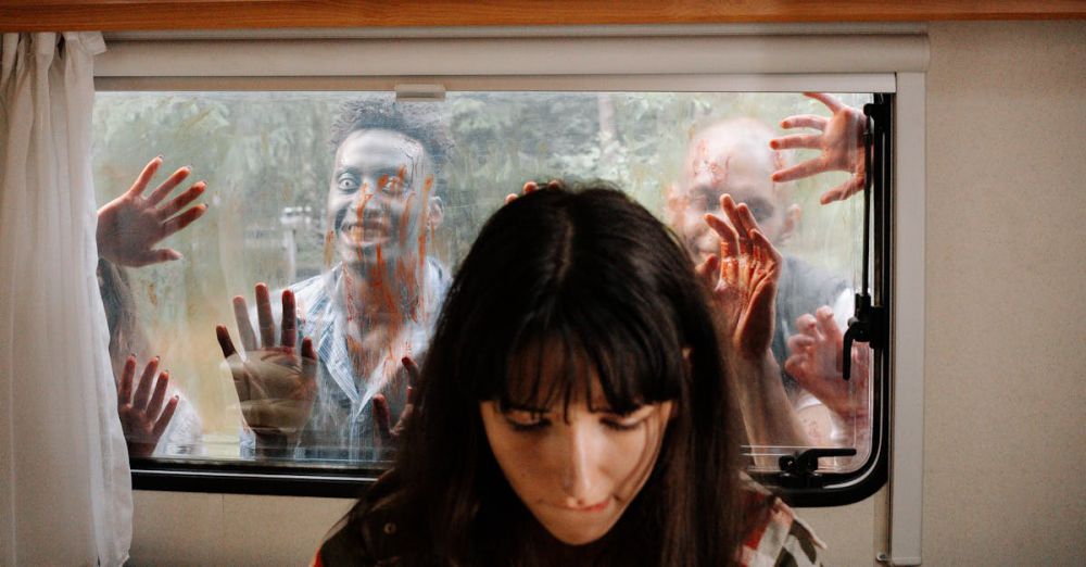 Shows - A woman sits unaware while terrifying zombies threaten through the window.